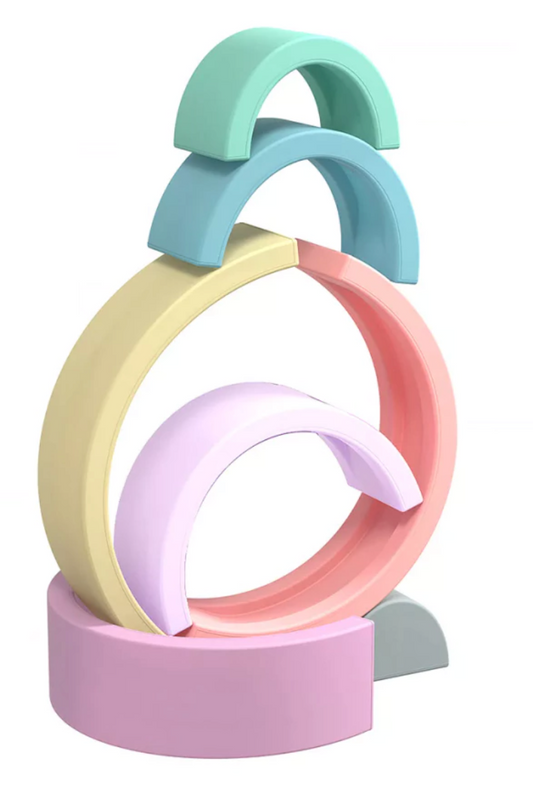 Arco-íris feito de tiras de silicone nas cores cinza, verde água, azul, roxo, lilás, laranja claro e amarelo claro. Peças desmontáveis para brincar e empilhar e encaixar. Peças colocadas em outro formato para ilustrar formas de brincar.