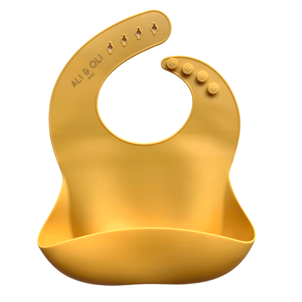 Babador de silicone com bolso cata migalha na cor amarelo mostarda.