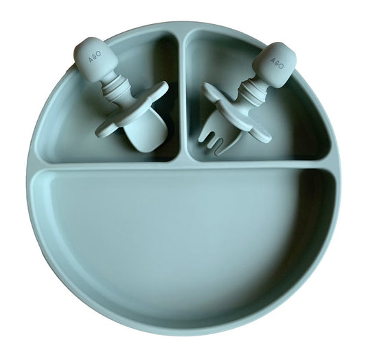 Prato de silicone com duas divisorias na vertical e uma divisoria na horizontal e duas talheres de silicone, tudo na cor verde sage.
