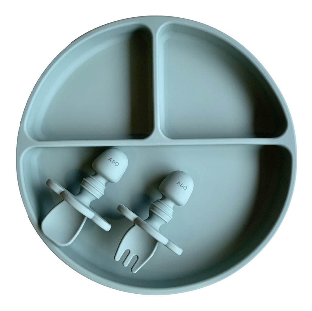 Prato de silicone com duas divisorias na vertical e uma divisoria na horizontal e duas talheres de silicone, tudo na cor verde sage.